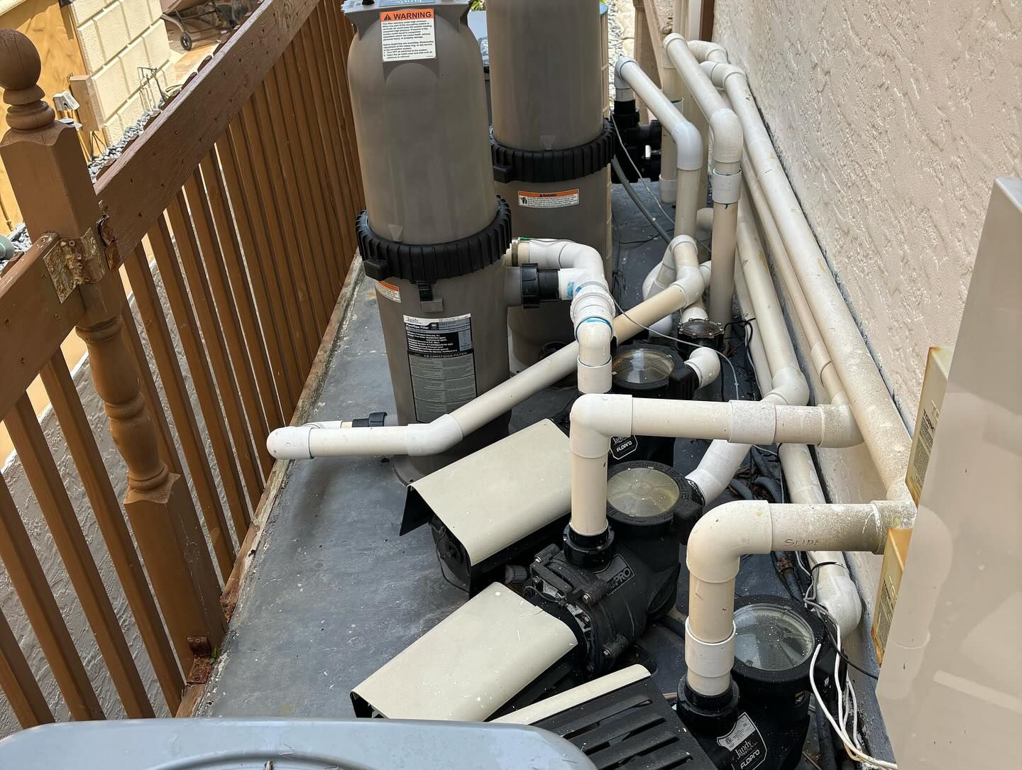 A row of swimming pool equipment is sitting on the side of a building.