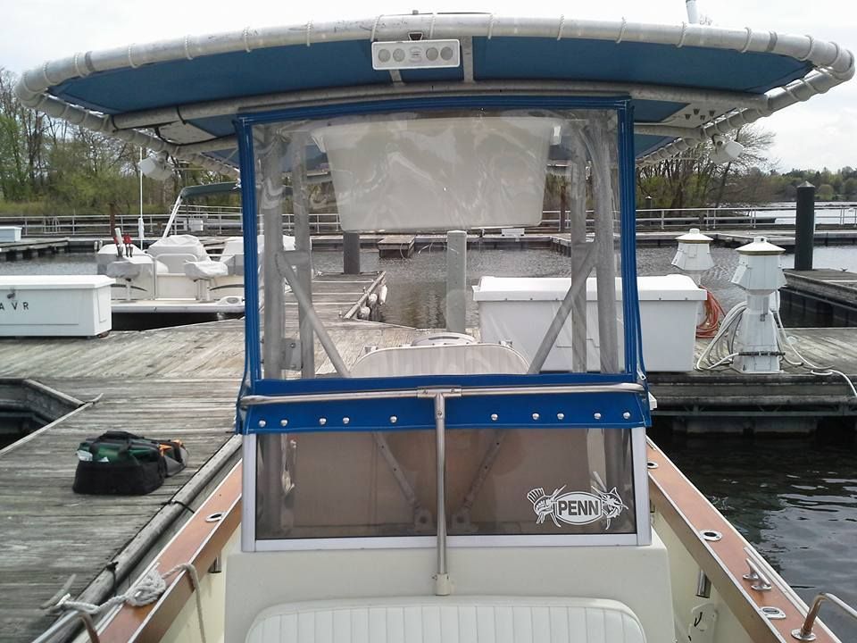 Blue-and-white boat cabin docked at a marina with yachts in the background
