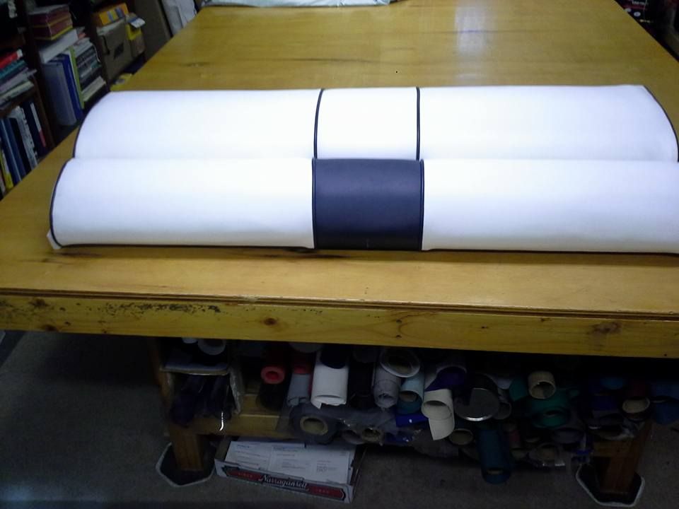 White and dark gray foam cushion on a wooden table in a workshop or studio