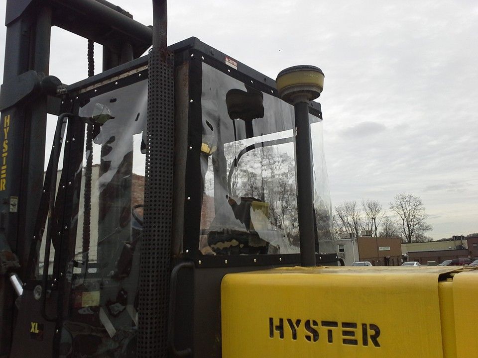 Yellow Hyster forklift in an outdoor lot under a cloudy sky