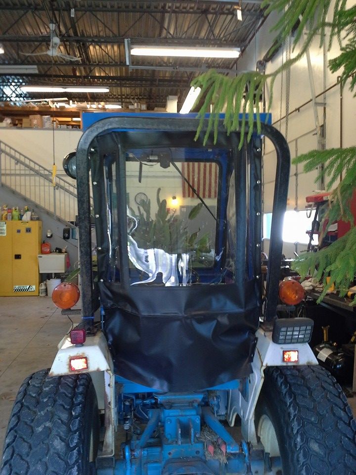 Blue tractor or forklift in an indoor warehouse, viewed from the front.