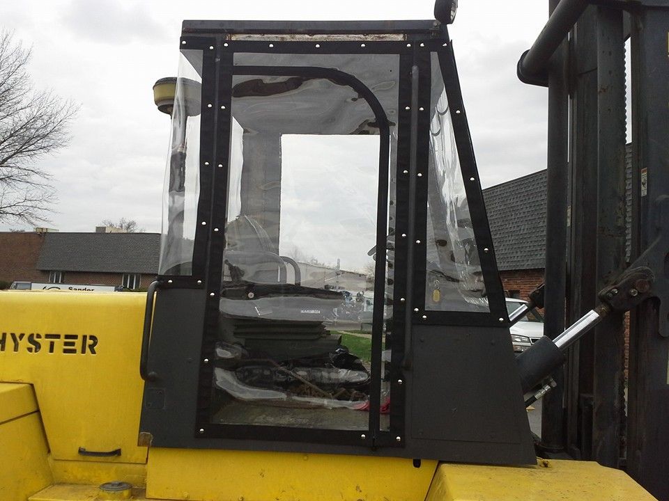 Yellow forklift cab with black frame and glass windows outdoors