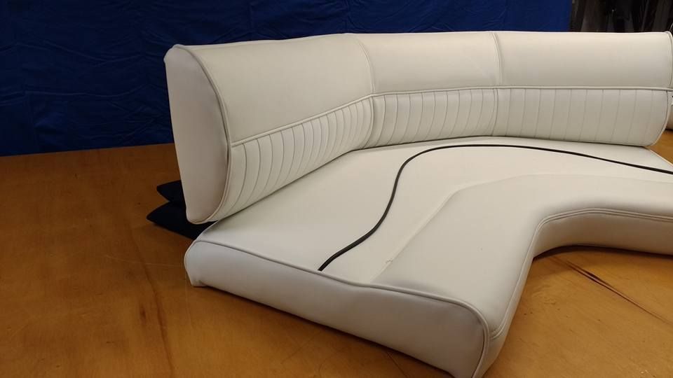 White sectional sofa on a wooden floor against a dark blue wall