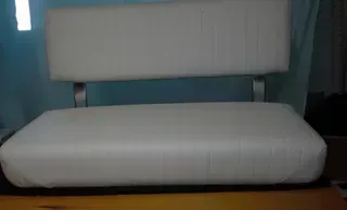 White cushioned chair with a backrest against a blue wall