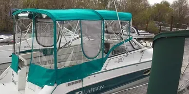 White boat with teal canopy moored at a dock