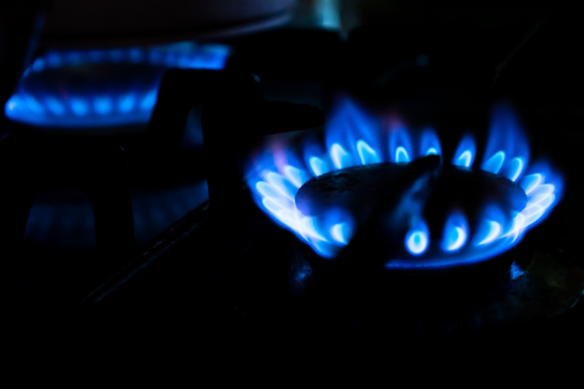 A close up of a gas burner with blue flames.