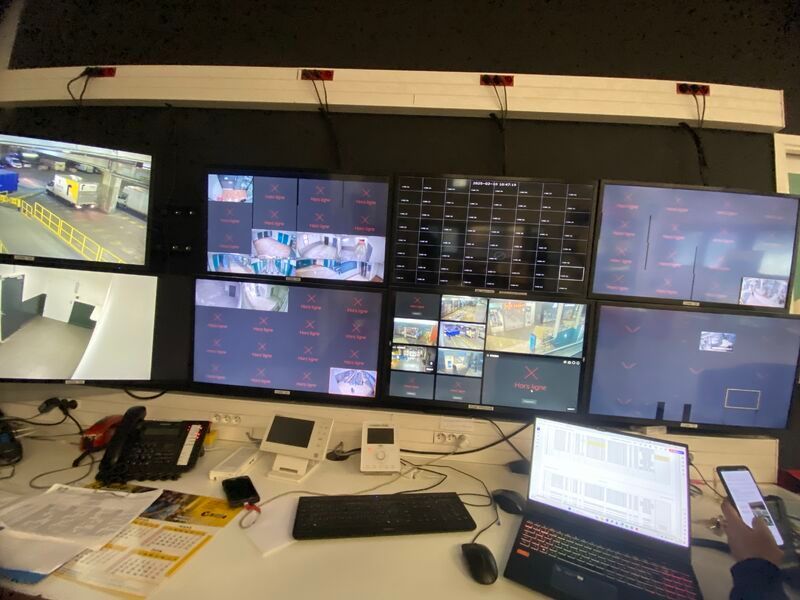 Un bureau avec beaucoup d'écrans et un ordinateur portable