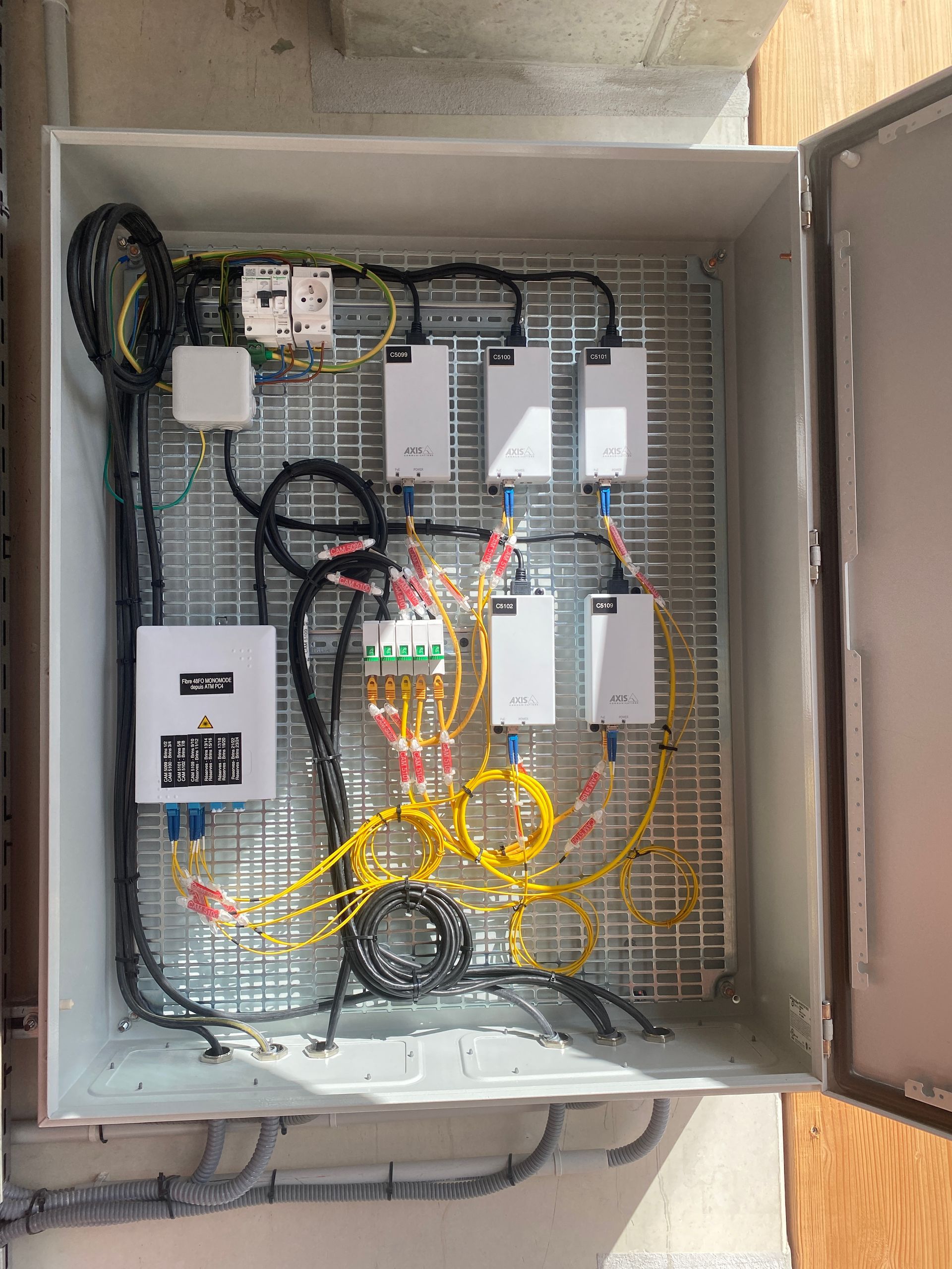 Une boîte remplie de nombreux fils et équipements électriques.