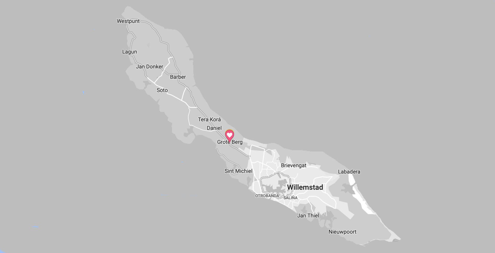 Kaart van het eiland Curaçao, witgrijs van kleur, met namen van plaatsen en wegen.