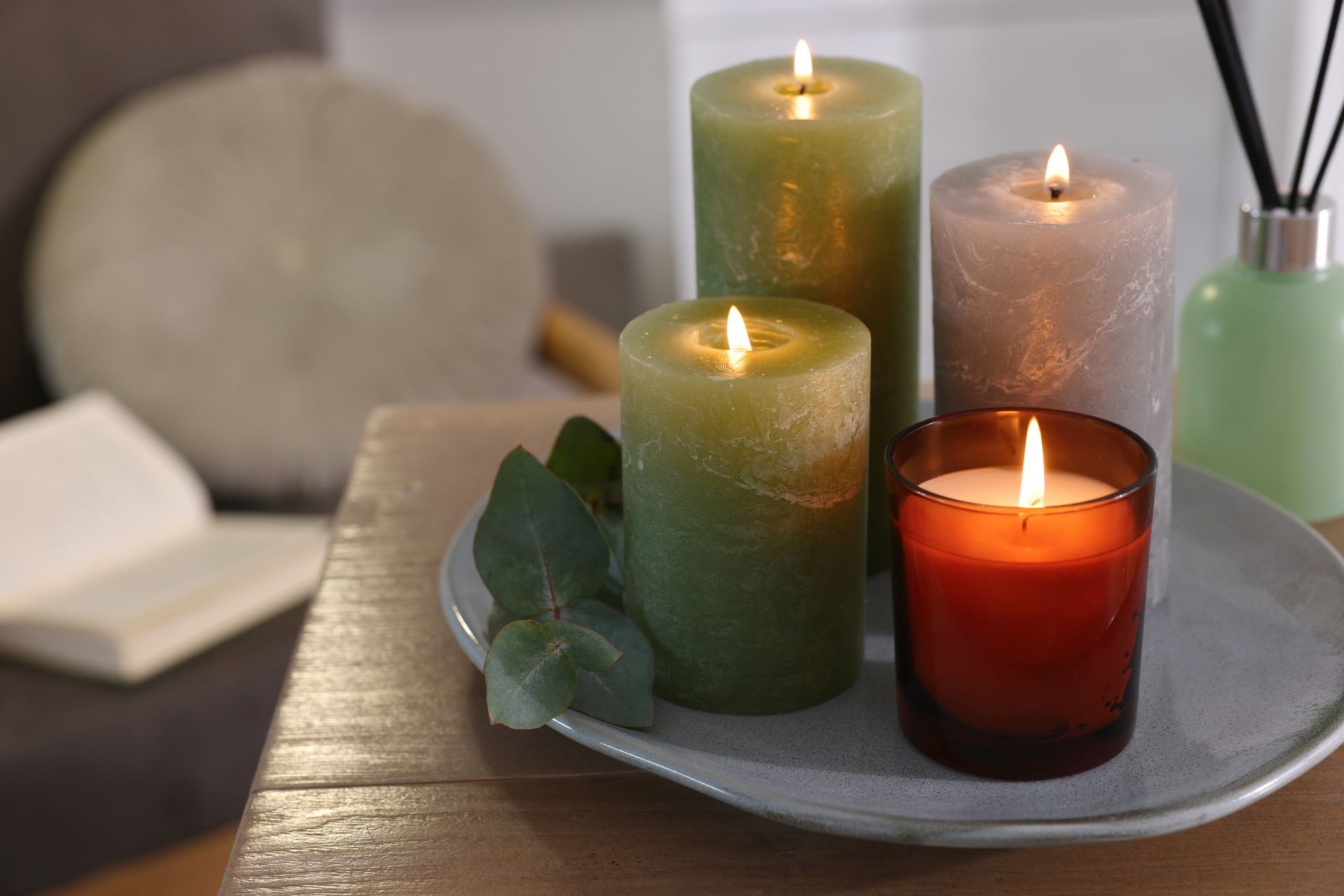 Four candles are sitting on a plate on a wooden table.