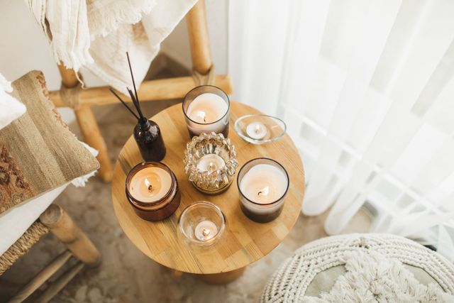 A wooden table topped with candles in a living room.