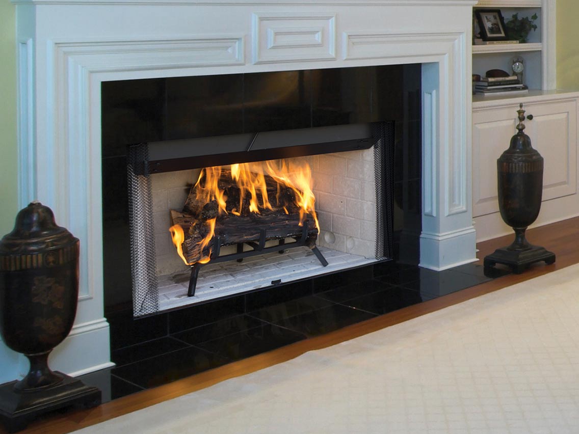 A fireplace is lit up in a living room with a white mantle