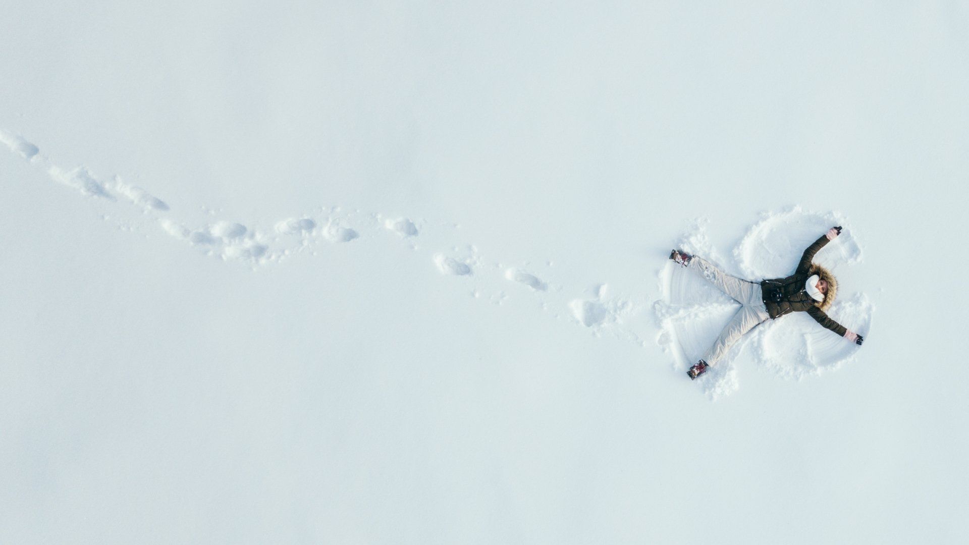 A person is making a snow angel in the snow.