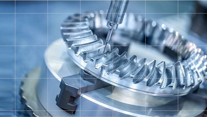 A close-up of a metal gear being machined by an industrial tool on a grid-pattern background.