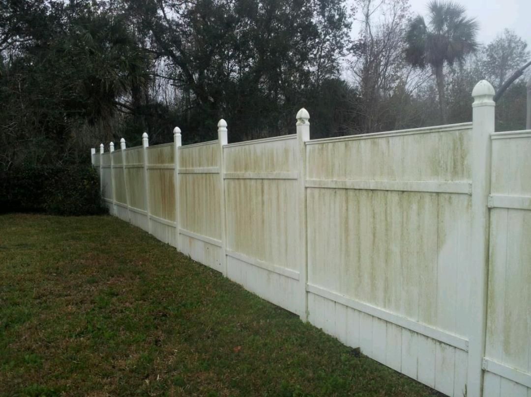 A white fence is sitting in the middle of a grassy field.