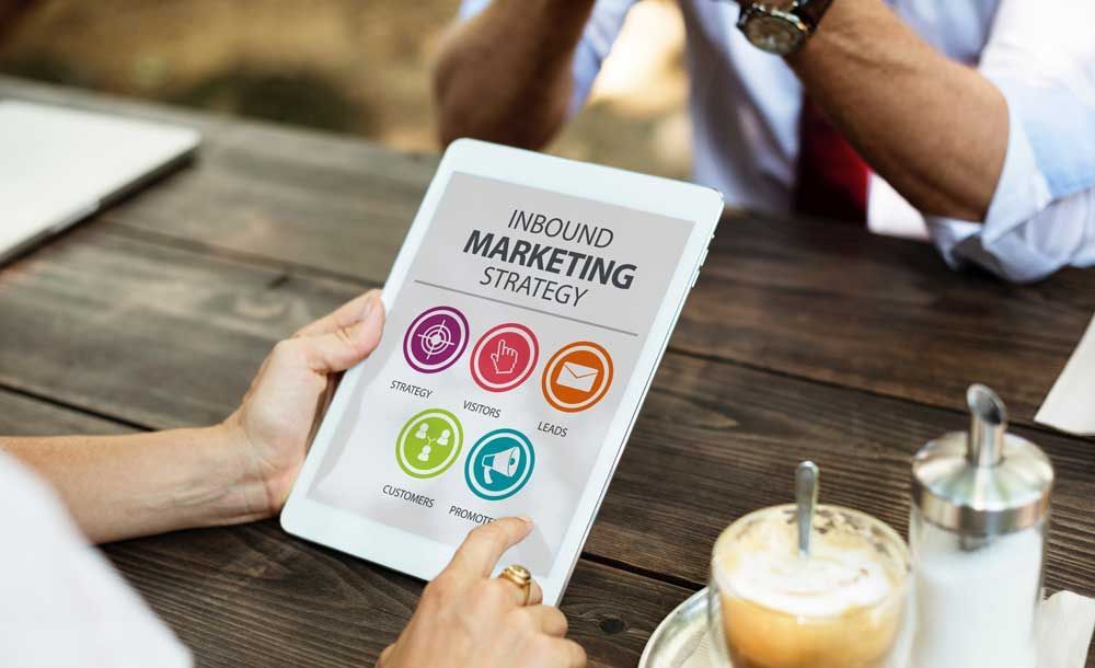 A person is holding a tablet with inbound marketing strategy on it. A person is holding a tablet with inbound marketing strategy on it.
