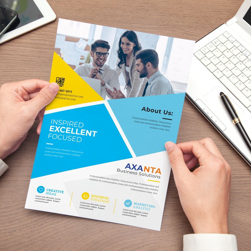 A person is holding a flyer with a picture of a group of people on it. A person is holding a flyer with a picture of a group of people on it.
