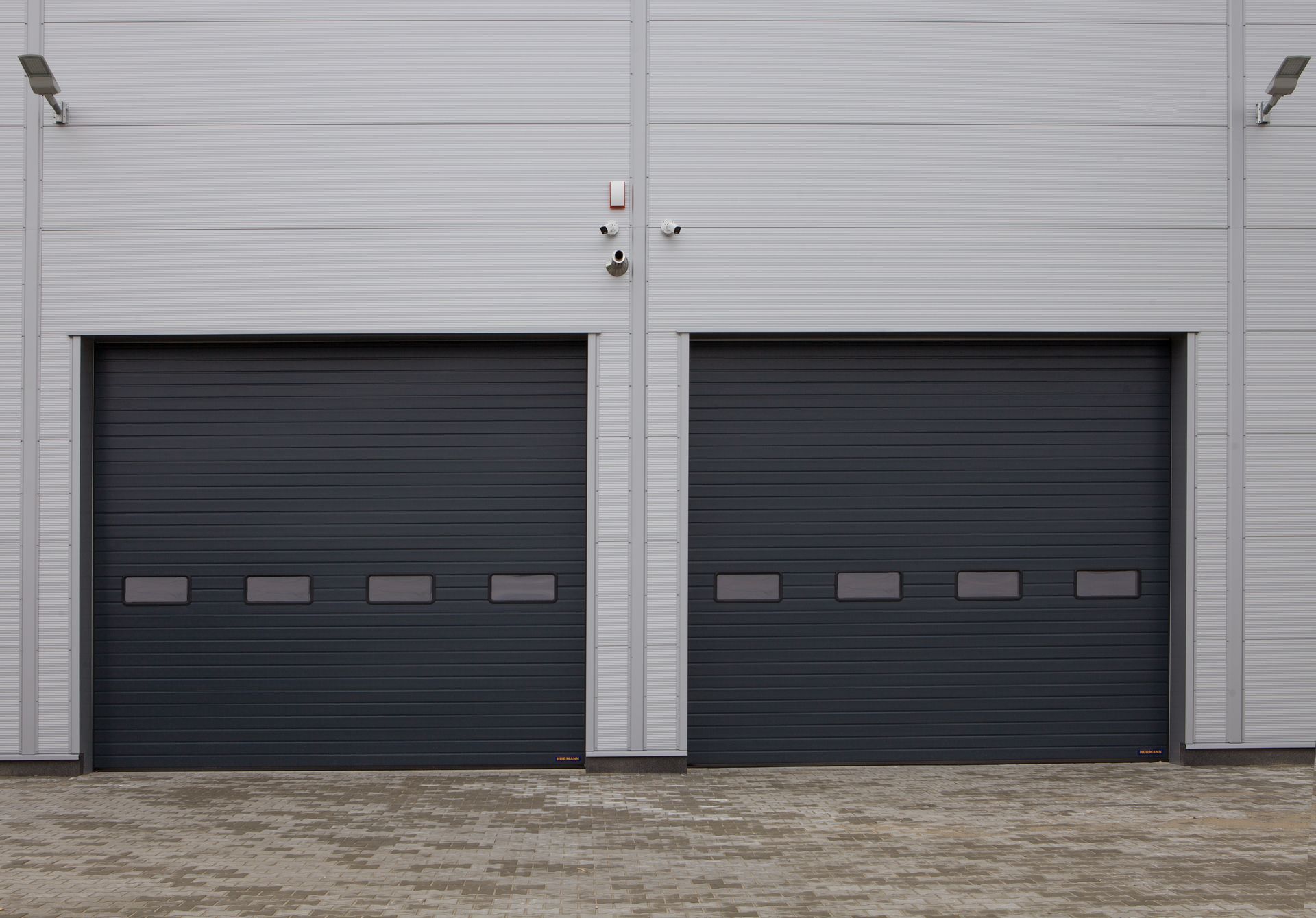 Two dark commercial garage doors on an industrial building. Two dark commercial garage doors on an industrial building.