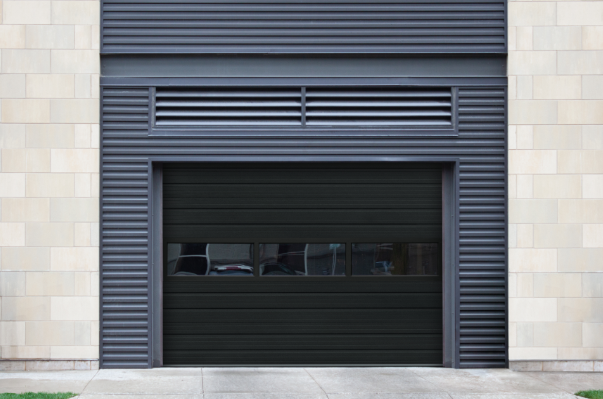 There are two white garage doors in front of a brick house.