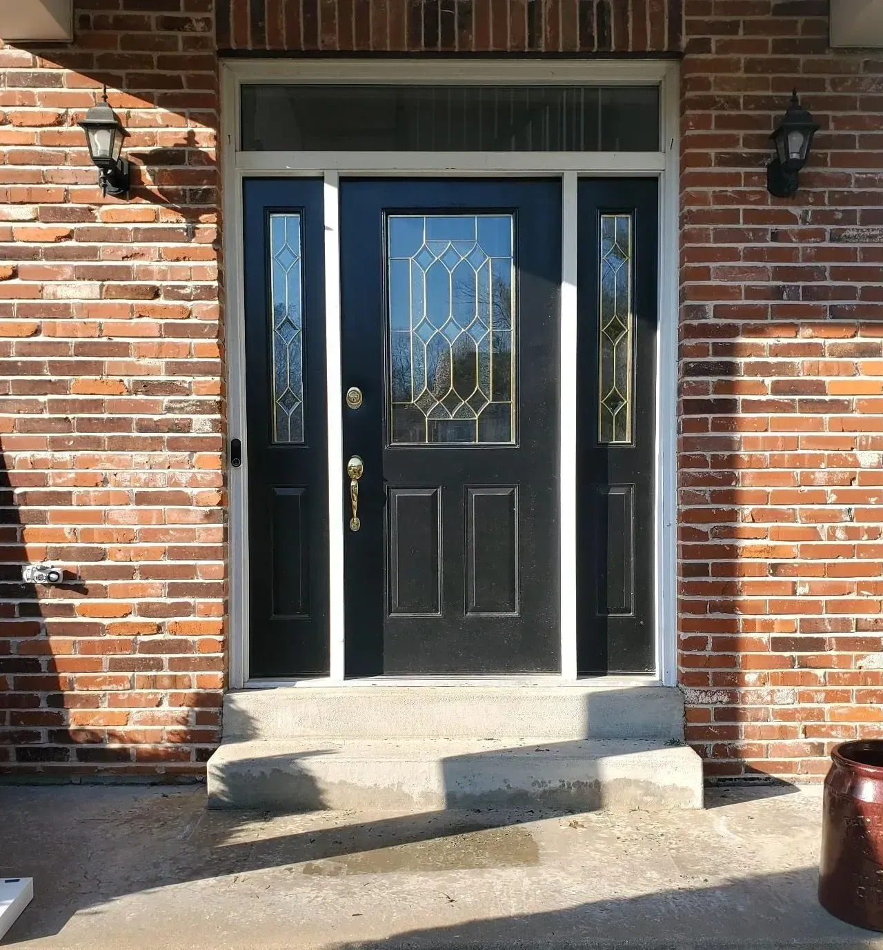 A brick building with a black door and steps