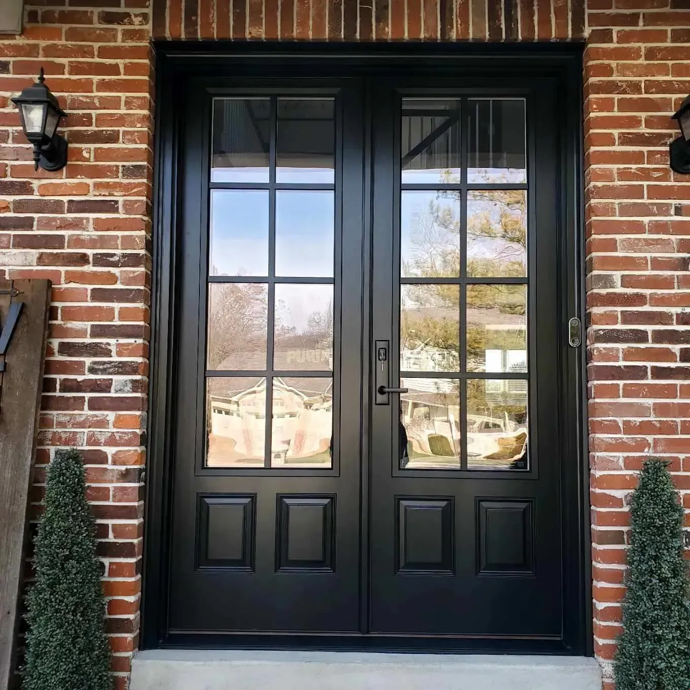 A black front door is on a brick building.