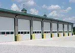 A row of garage doors are lined up in front of a building.