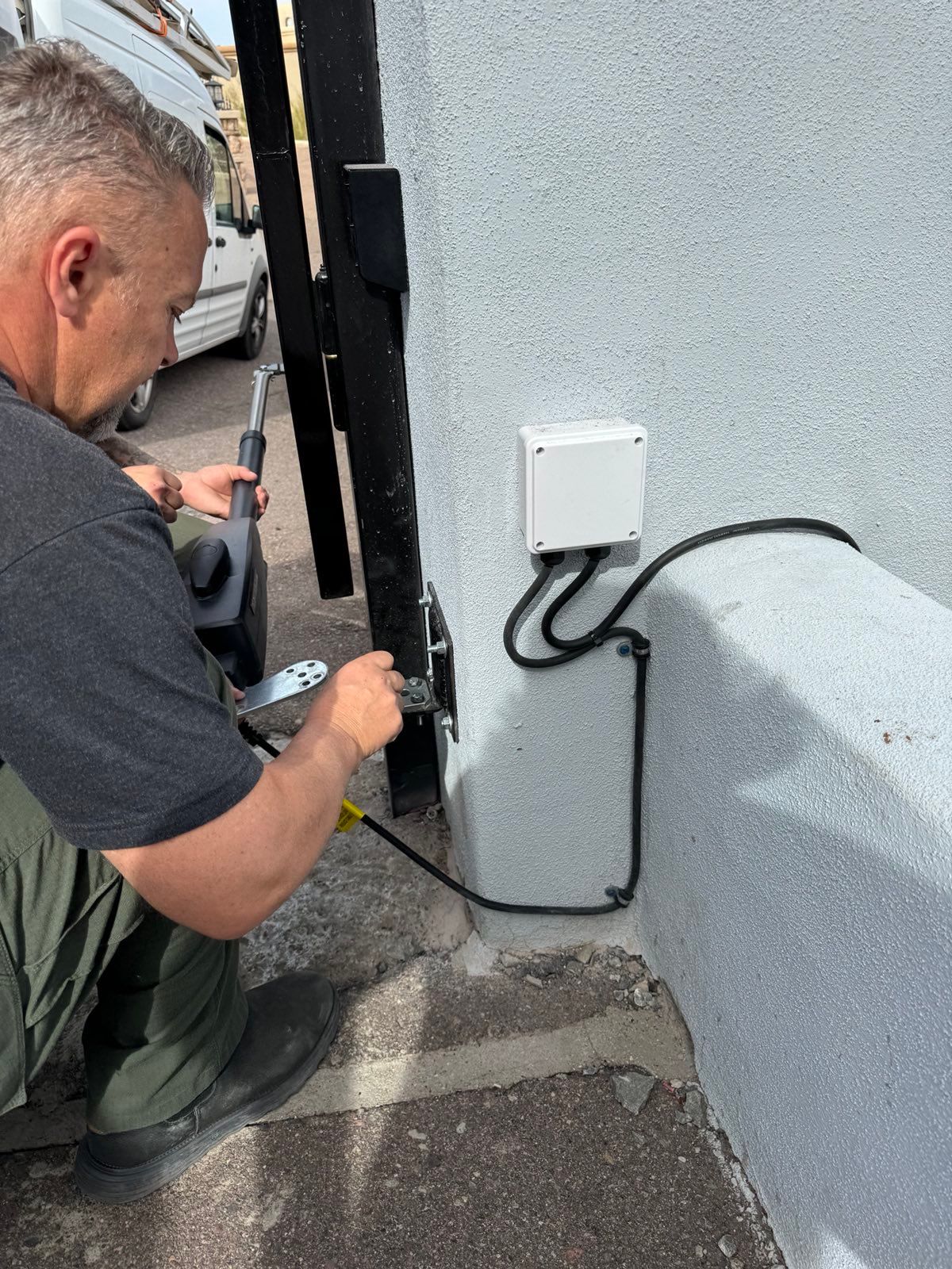A man is working on a fence with a hammer.