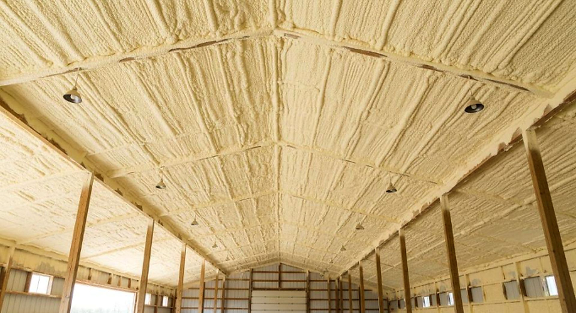 Spray foam coats a large ceiling and wall area, after Spray Foam Insulation Services in Muncie, IN for thermal coverage.