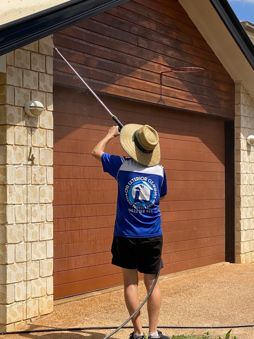 Woman is Washing the Side of a House With a Hose — CPR Exterior Cleaning in Elliott Heads, QLD