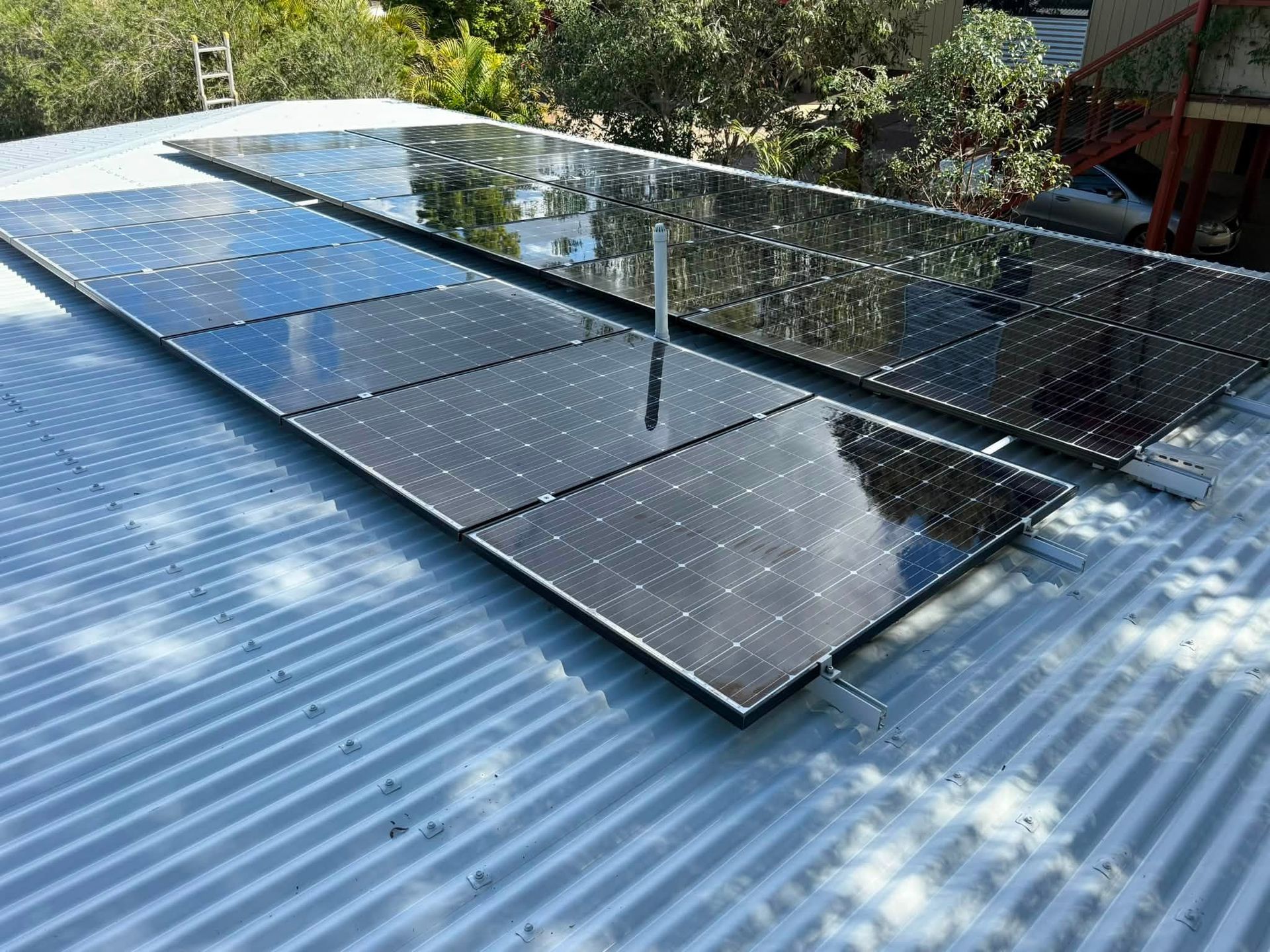 Solar Panels Mounted on a Corrugated Metal Roof Under Bright Sunlight — CPR Exterior Cleaning in Bundaberg South, QLD