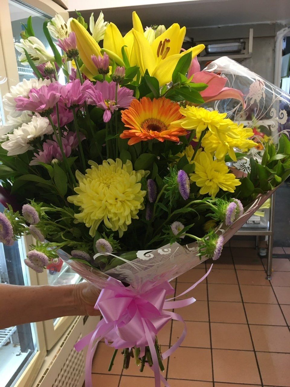 A Person Is Holding a Bouquet of Flowers with A Pink Bow — Fiori With Love in Ingham, QLD