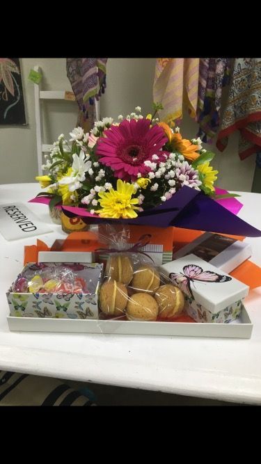 A Bouquet of Flowers Sits on A Table Next to A Box of Cookies — Fiori With Love in Ingham, QLD