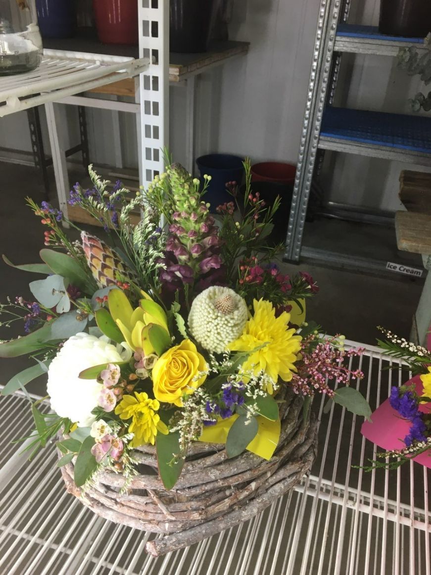 A Basket Filled with Flowers Is Sitting on A Shelf — Fiori With Love in Ingham, QLD