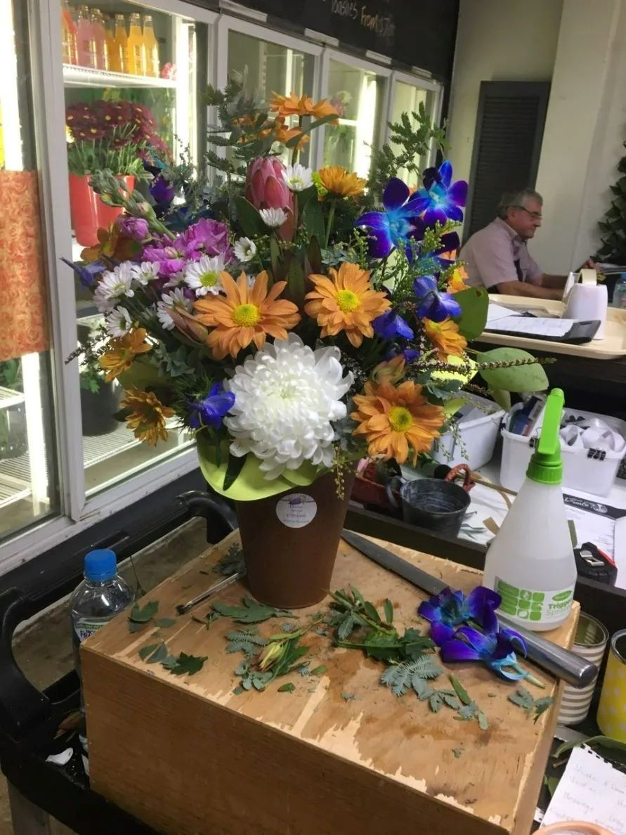 A Vase of Flowers Is Sitting on Top of A Wooden Box — Fiori With Love in Ingham, QLD