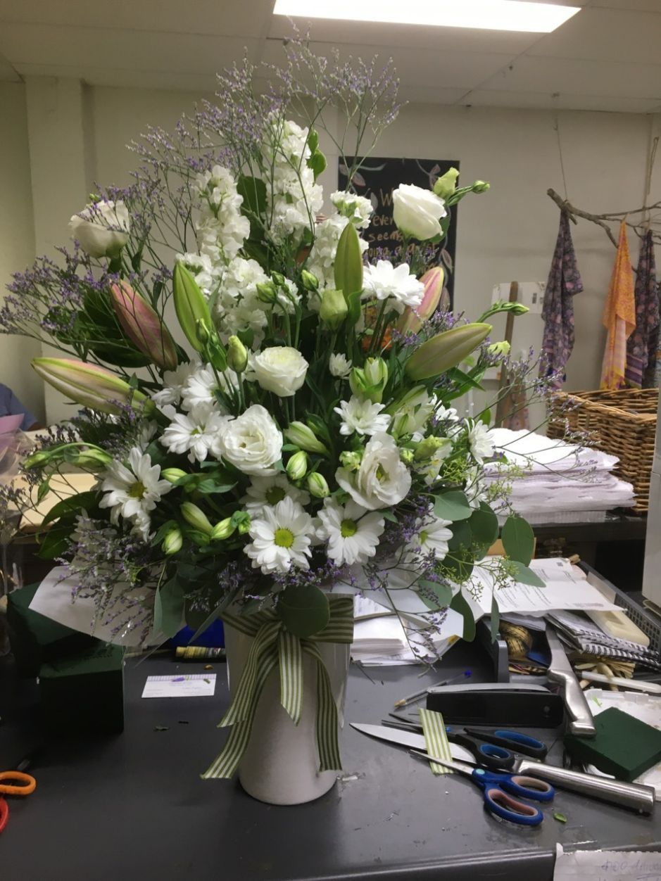 A Vase Filled with White Flowers Is Sitting on A Table — Fiori With Love in Ingham, QLD