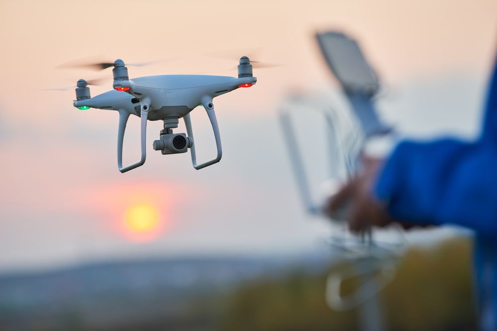 a person is flying a drone with a camera attached to it .