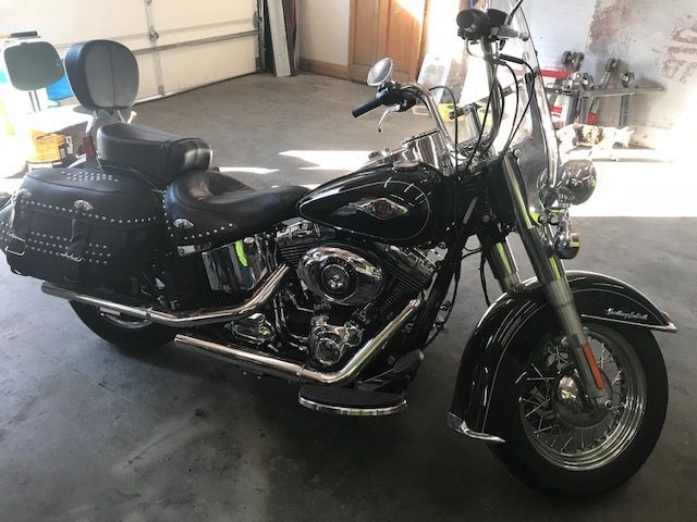 A black motorcycle is parked in a garage next to a garage door.