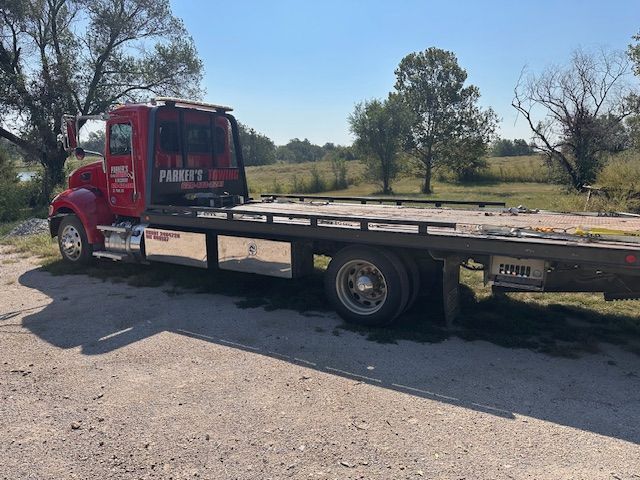A red tow truck is parked on the side of the road.