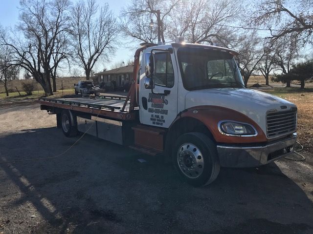 A tow truck is parked on the side of the road.
