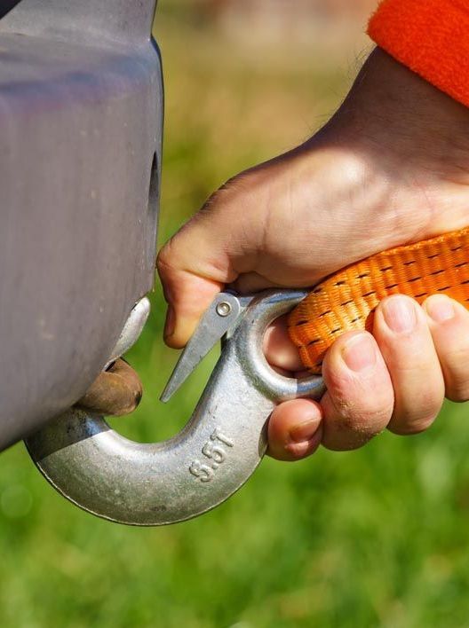 A person is holding a hook with a rope attached to it.