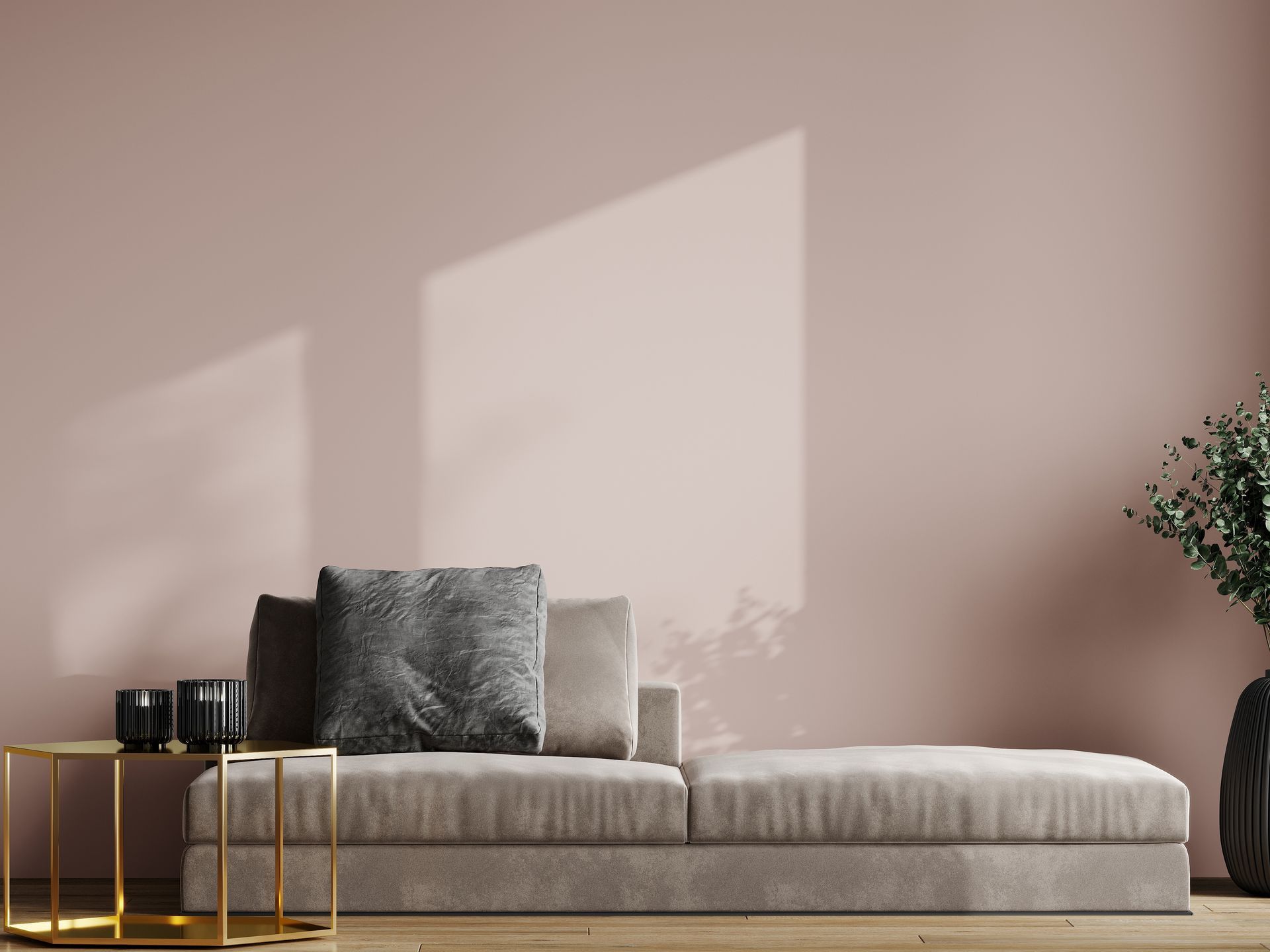 Modern living room with beige sofa, gold side tables, and soft sunlight on a pink wall.