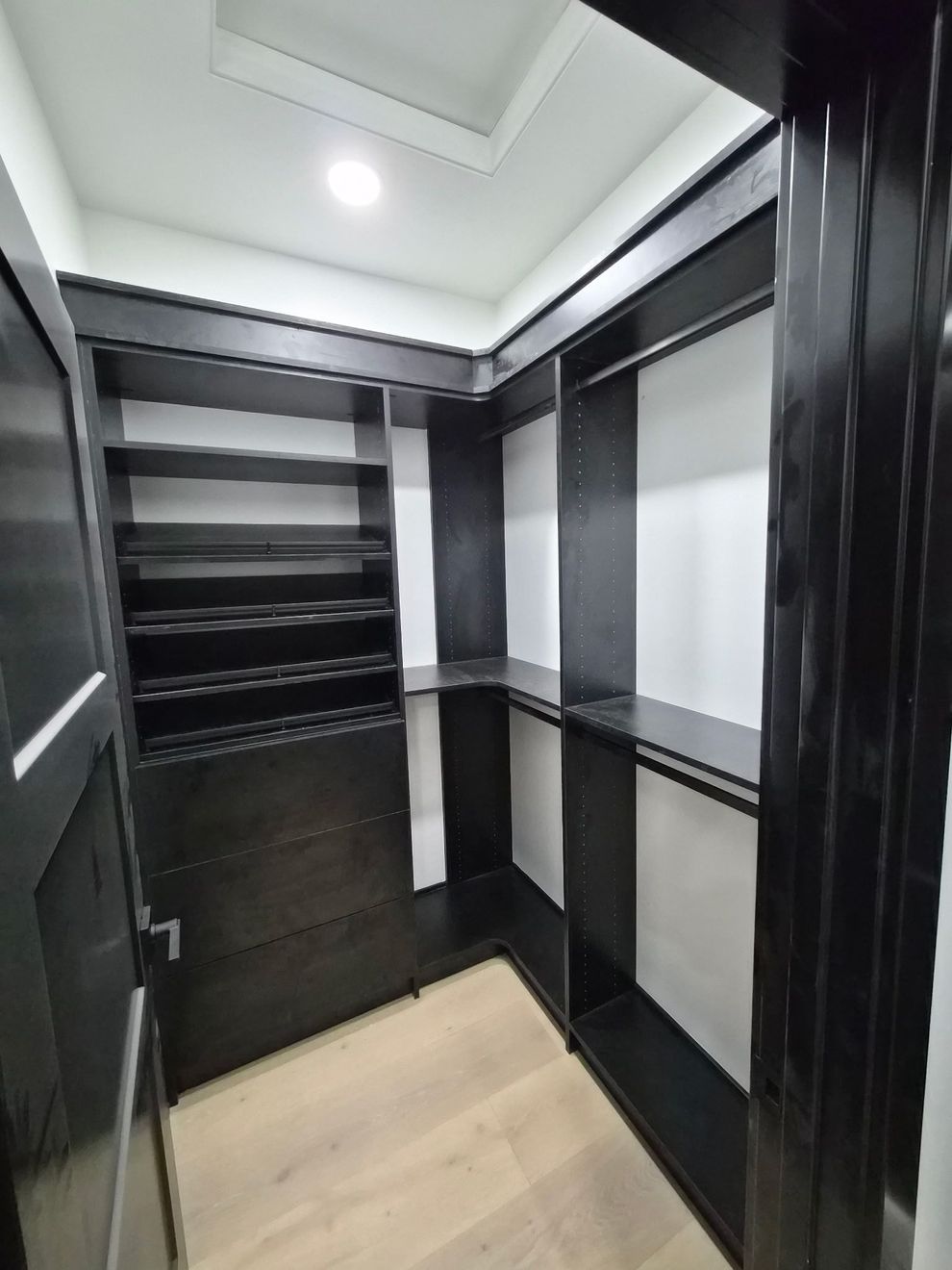 A smaller black walk-in closet