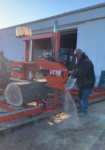 guy using sawmill to cut log