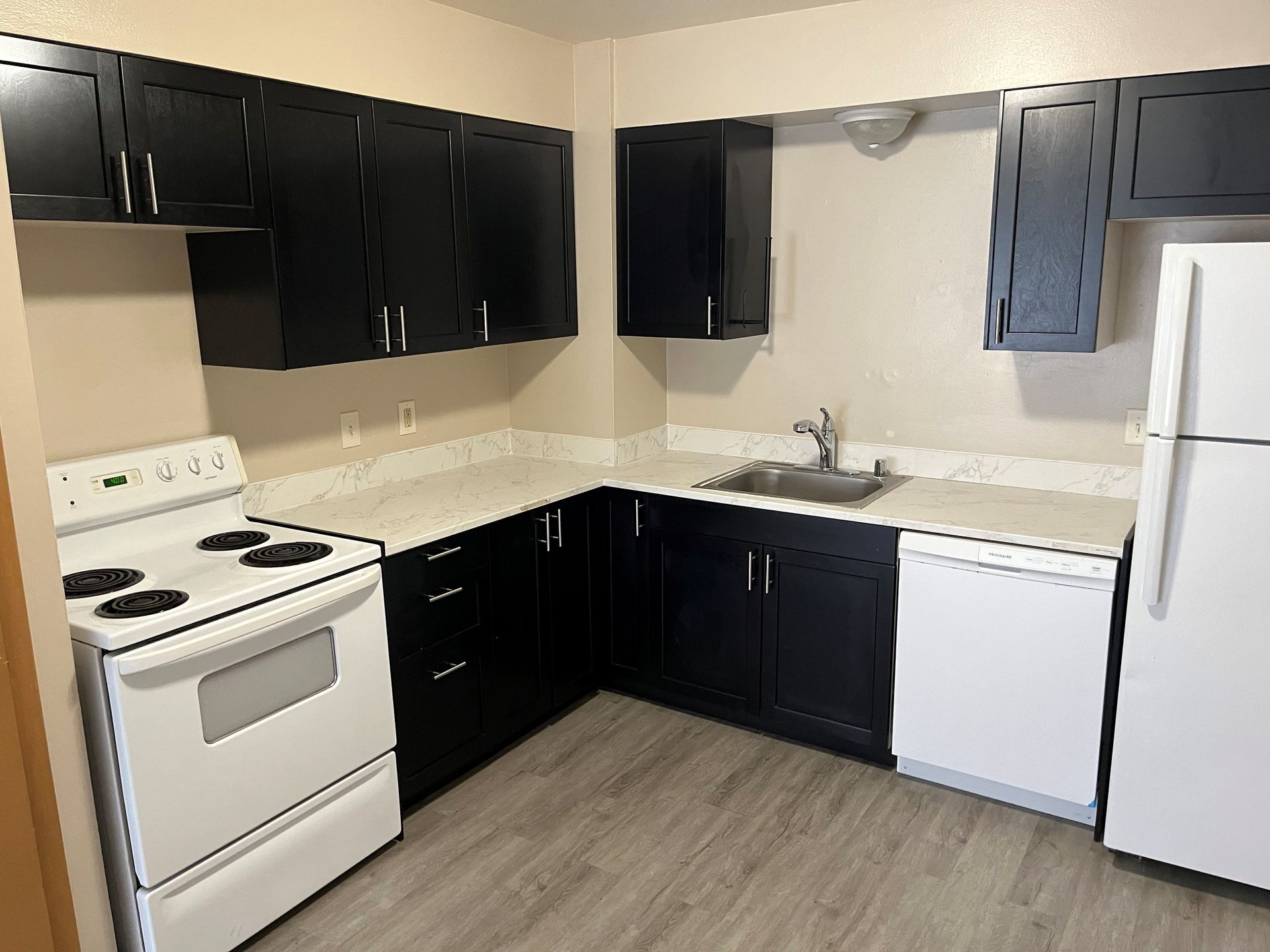 The club house at Rustic Woods Townhomes includes a brick fire place, tables, chairs, and full kitchen