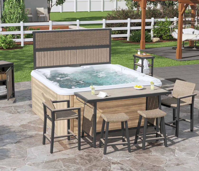 Outdoor hot tub with beige and brown wood panels, surrounded by bar stools and a patio table on a stone patio