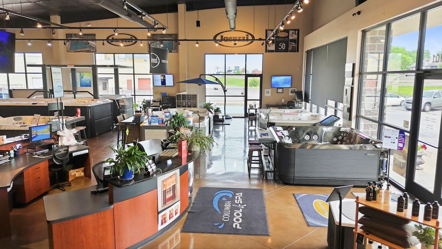 Bright, modern office lobby with reception desk, seating, tables, and large windows.
