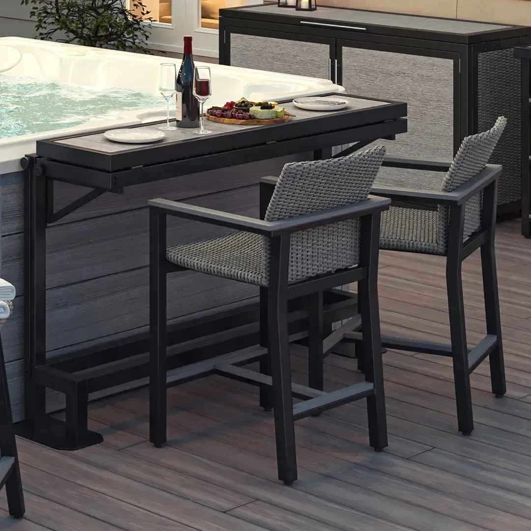 Outdoor patio bar table with two woven stools and drinks on a deck
