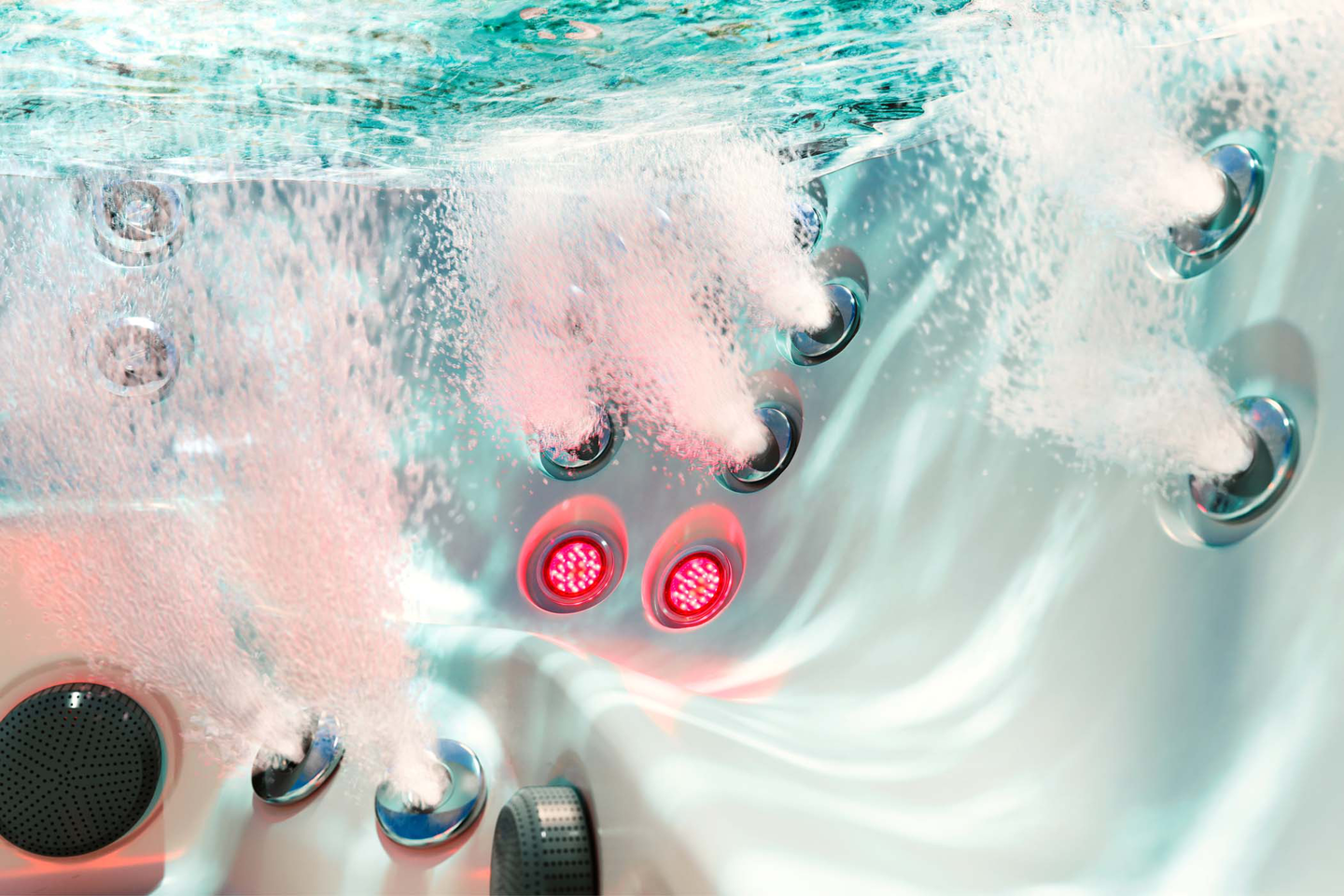 Hot tub control panel with glowing red buttons and jets swirling in turquoise water