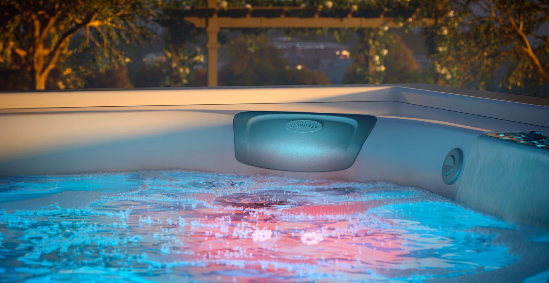 Lit hot tub with blue water and a central fountain at dusk