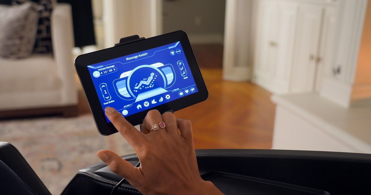 Person using a tablet with a blue dashboard interface in a living room